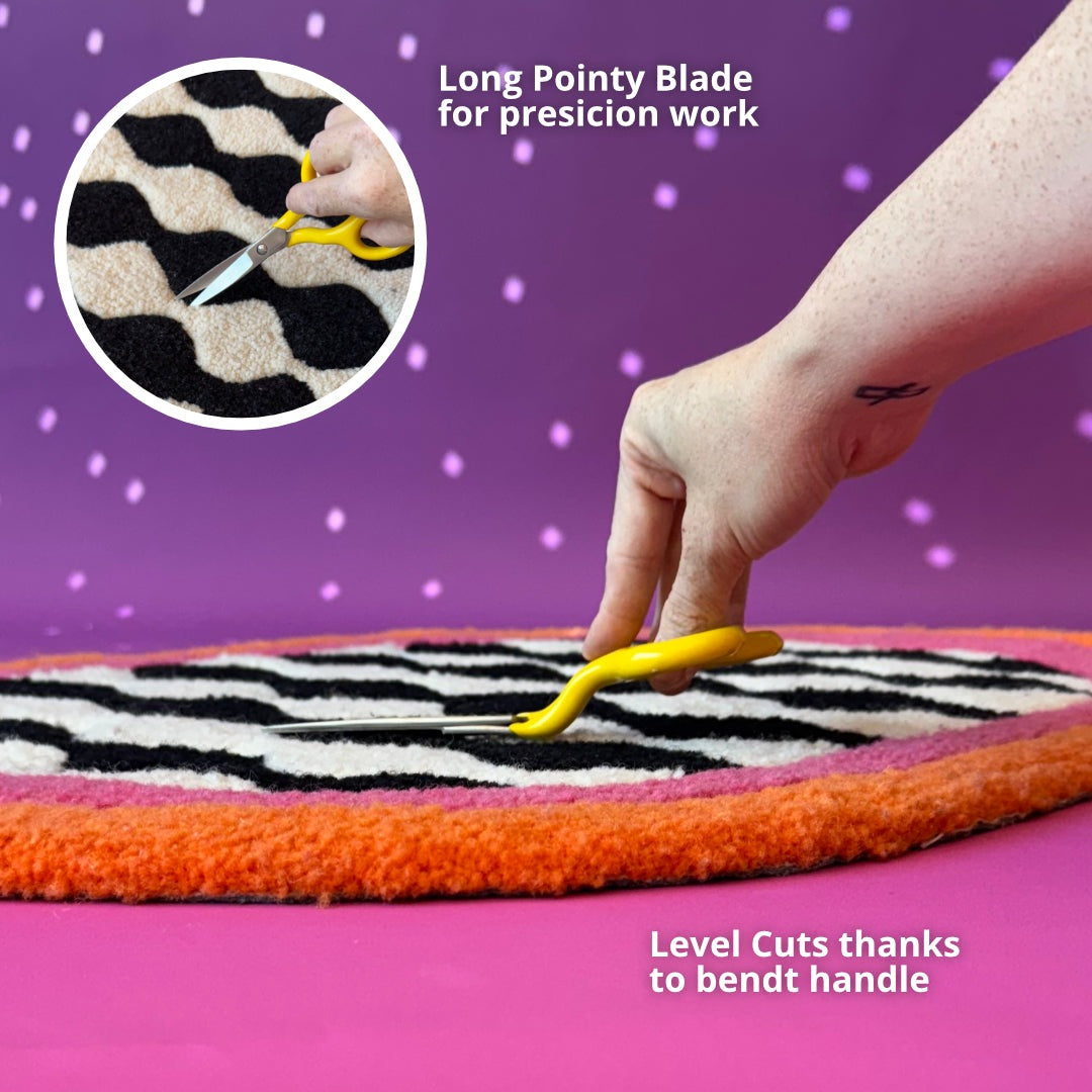 Bent carving scissors shaping a tufted rug, detail