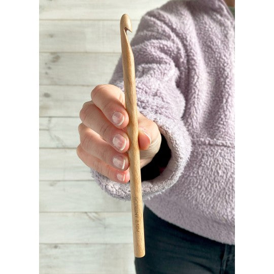 Beech wood crochet hook held in hand, in use