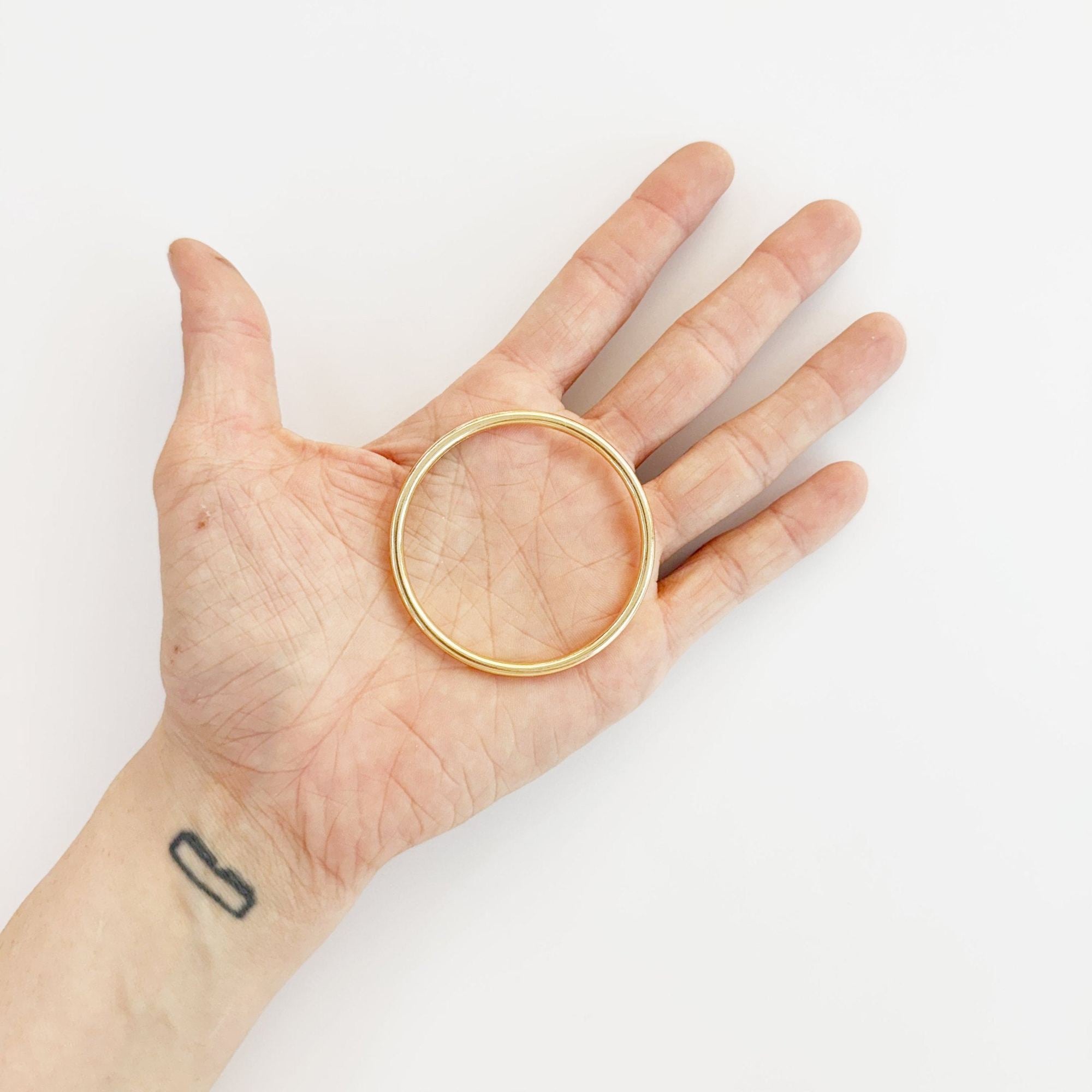 Goldener Metallring in der Hand, 50mm