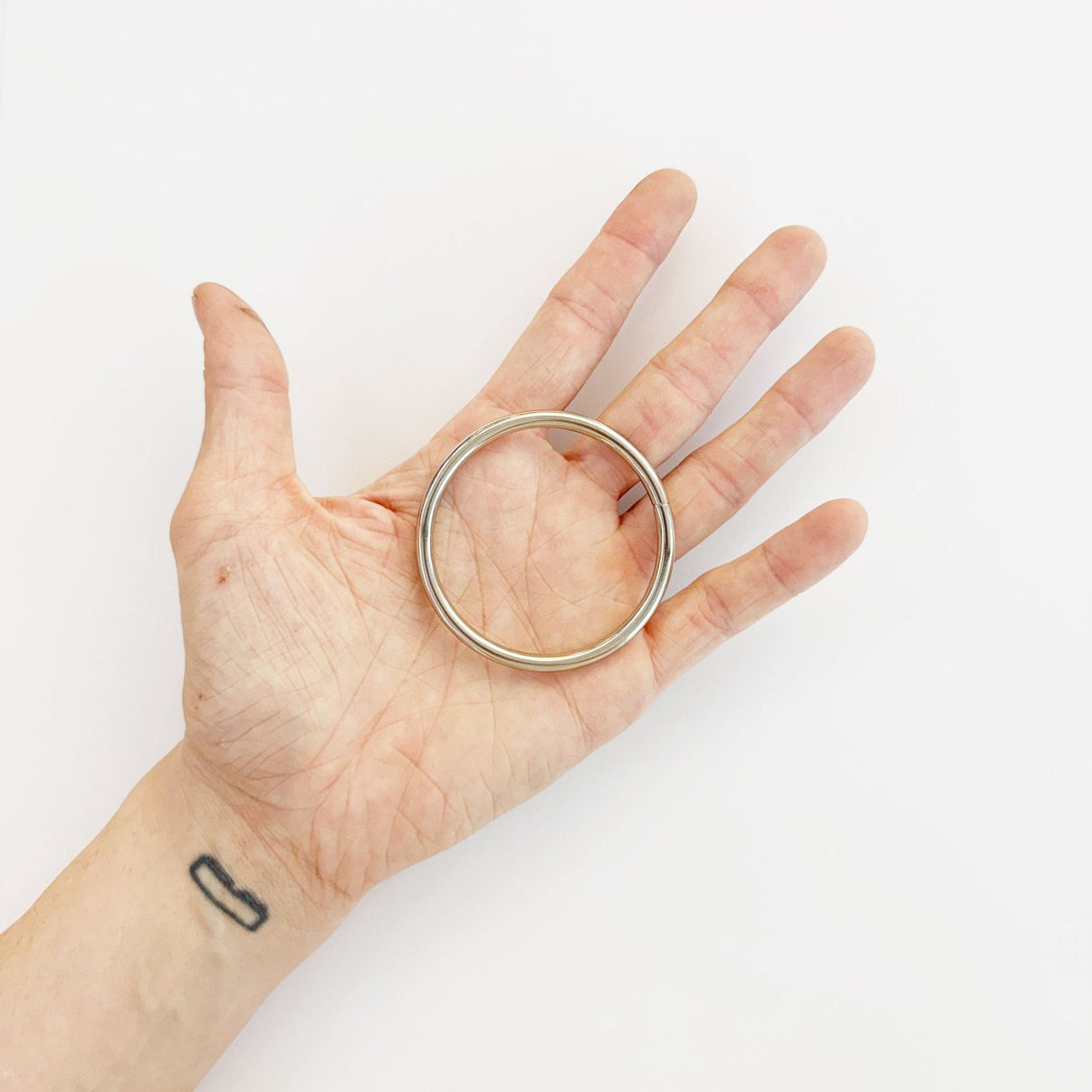 Silberner Metallring in der Hand, 50mm