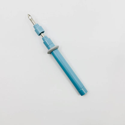 Clover punch needle held in hand, close-up
